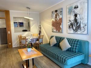 ein Wohnzimmer mit einer Couch und einem Tisch in der Unterkunft Exclusive Holiday Apartments in Villach