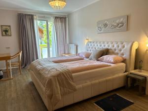 ein Schlafzimmer mit einem großen Bett und einem Tisch in der Unterkunft Exclusive Holiday Apartments in Villach