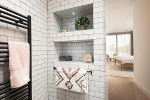 a bathroom with a white tiled wall with a fireplace at 1 The Bay - Stunning contemporary flat on the Scottish coast in Coldingham