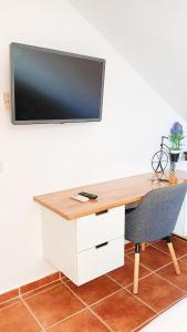 uma secretária com uma televisão na parede com uma cadeira em Selwo Studio em Estepona