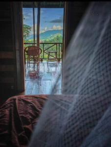 a room with a bed and a view of a balcony at Ban Oreo Homestay in Ban Pha Hu