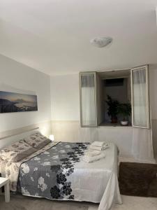 una camera da letto con un letto con una coperta bianca e nera di Casa Elena - casa vacanze Napoli centro a Napoli