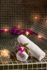 a bathroom with a towel and a flower and candles at Hotel Punta Tragara in Capri