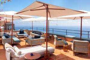 a deck with chairs and umbrellas on a cruise ship at Hotel Punta Tragara in Capri