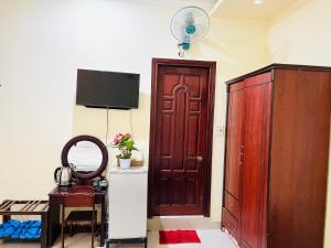 ダラットにあるKhách sạn Xuân Quỳnhの木製のドア、テーブル、鏡が備わる客室です。