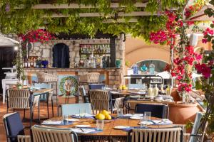 restauracja ze stołami i krzesłami oraz bar w obiekcie Hotel Punta Tragara w mieście Capri