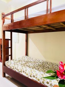 ダラットにあるKhách sạn Xuân Quỳnhの二段ベッドが備わるフラワーアレンジメント付きの客室です。