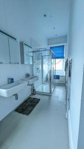 a white bathroom with two sinks and a mirror at Upstairs Downstairs Regency Apartments in Cheltenham