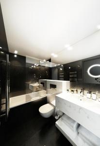 a bathroom with a sink, toilet, and bathtub at Howard Hotel Paris Orly Airport in Paray-Vieille-Poste