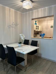 ein Esszimmer mit einem weißen Tisch und Stühlen in der Unterkunft Exclusive Holiday Apartments in Villach