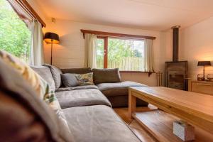a living room with a couch and a table at Spacious wooden cottage with infra-red sauna at Veluwe in Putten