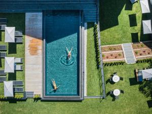 two people swimming in a pool in a house at Montanaris Apartments in Villabassa