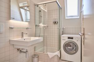 a bathroom with a sink and a washing machine at City Apartment Bern, perfect located and spacious in Bern +24 photos