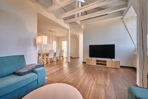 a living room with a blue couch and a flat screen tv at City Apartment Bern, perfect located and spacious in Bern