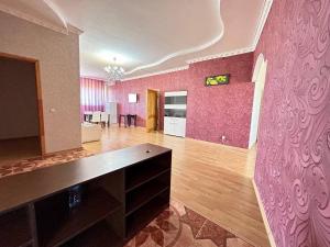 a living room with pink walls and a dining room at Просторная 3 комнатная квартира in Atyraū +12 photos