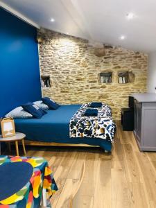 a bedroom with a bed and a brick wall at La ti case - studio de charme au coeur du medoc in Saint-Laurent-de-Médoc