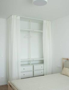 a white bedroom with a bed with white curtains at Stylish Urban Residence with parking spot in Nivy