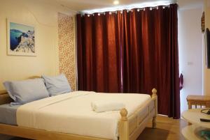 - une chambre avec un grand lit et des rideaux rouges dans l'établissement บ้านแสนคราม หัวหิน, à Ban Huai Sai Tai