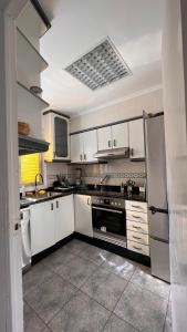 uma cozinha com armários brancos e um frigorífico em ValenciaBeach em Mareny Blau