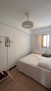 um quarto com uma cama, uma janela e um candeeiro em ValenciaBeach em Mareny Blau