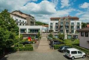 a building with cars parked in a parking lot at Posthotel Rotenburg in Rotenburg an der Fulda