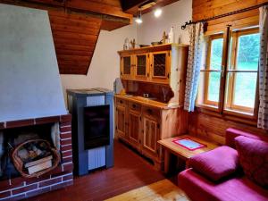 uma sala de estar com lareira e um sofá vermelho em Alpine hut in St Lorenzen ob Murau Styria 
