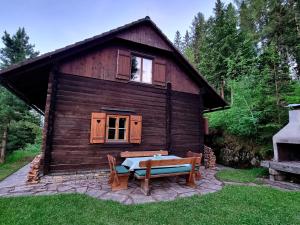 uma cabana de madeira com um banco à frente em Alpine hut in St Lorenzen ob Murau Styria 