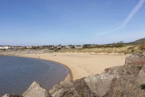 a beach with a bunch of rocks and water at Stunning comfortable home from home in Millom