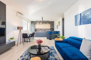 sala de estar con sofá azul y mesa en BNB Slovakia Ovocné sady Airport Apartment, en Bratislava