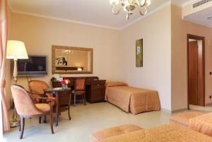 een hotelkamer met een slaapkamer met een bureau en een bed bij Hotel Federico II in Enna