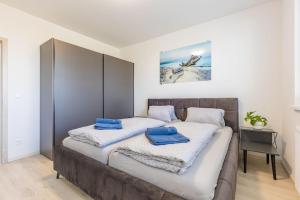 two beds in a bedroom with blue towels on them at BALRENT Slovakia Ovocné sady Airport Apartment in Bratislava