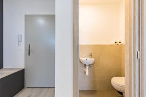 y baño con aseo blanco y lavamanos. en BNB Slovakia Ovocné sady Airport Apartment en Bratislava