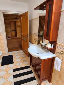 Lucky Rönk vendégház في Vîlcele: حمام مع حوض ومرحاض ومرآة