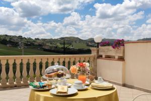 uma mesa amarela com comida em cima de uma varanda em Hotel Federico II em Enna
