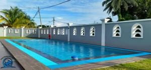 a swimming pool in front of a white building at PD Beach Villa in Port Dickson