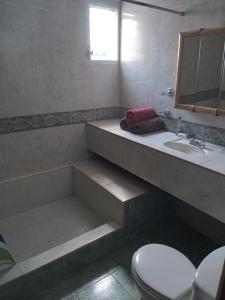 uma casa de banho com uma banheira, um lavatório e um WC. em Yucatan Vista Inn em Mérida