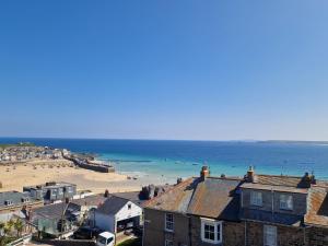 een uitzicht op een strand met huizen en de oceaan bij Little Gem in St Ives