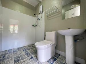 een badkamer met een wit toilet en een wastafel bij Moukdavan Guesthouse in Luang Prabang