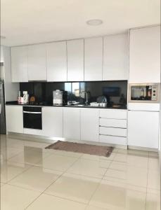 a white kitchen with white cabinets and appliances at Luxury Apartment Ocean Views in Praia