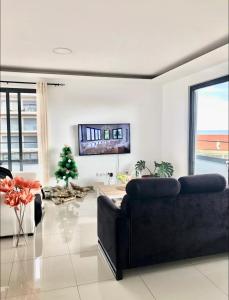a living room with a couch and a tv on the wall at Luxury Apartment Ocean Views in Praia