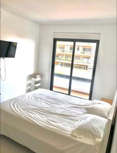 a white bed in a room with a window at Luxury Apartment Ocean Views in Praia