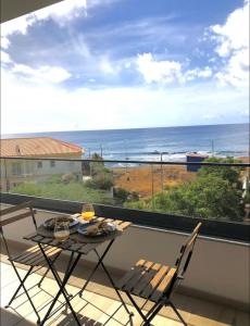 a table and chairs on a balcony with a view of the ocean at Luxury Apartment Ocean Views in Praia