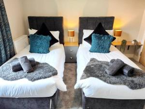 two beds with pillows on them in a bedroom at Carvetii - ANNE House Room 1 - Dbl bed Ground floor en-suite in Carlisle +2 photos