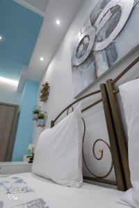 a bedroom with a bed with white pillows and plates on the wall at 'The Aqua'House Project In Athens in Athens