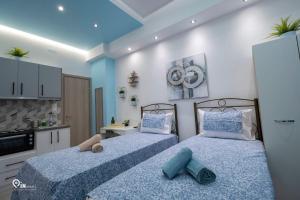 2 camas en un dormitorio con azul y blanco en 'The Aqua'House Project In Athens, en Atenas