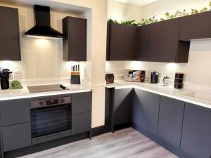 a kitchen with white counter tops and brown cabinets at Carvetii - ANNE House Room 1 - Dbl bed Ground floor en-suite in Carlisle