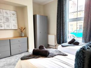 1 Schlafzimmer mit 2 Betten und einem großen Fenster in der Unterkunft Carvetii - ANNE House Room 1 - Dbl bed Ground floor en-suite in Carlisle