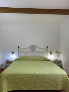 ein Schlafzimmer mit einem grünen Bett mit zwei Nachttischen in der Unterkunft Pantalica Ranch Agriturismo Siciliano in Sortino