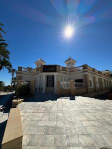 a large building with the sun in the sky at Apartamentos Maruja in Los Baños +32 photos