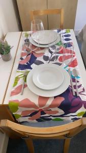 a table with plates and glasses on a colorful table cloth at Private room in Camden in London